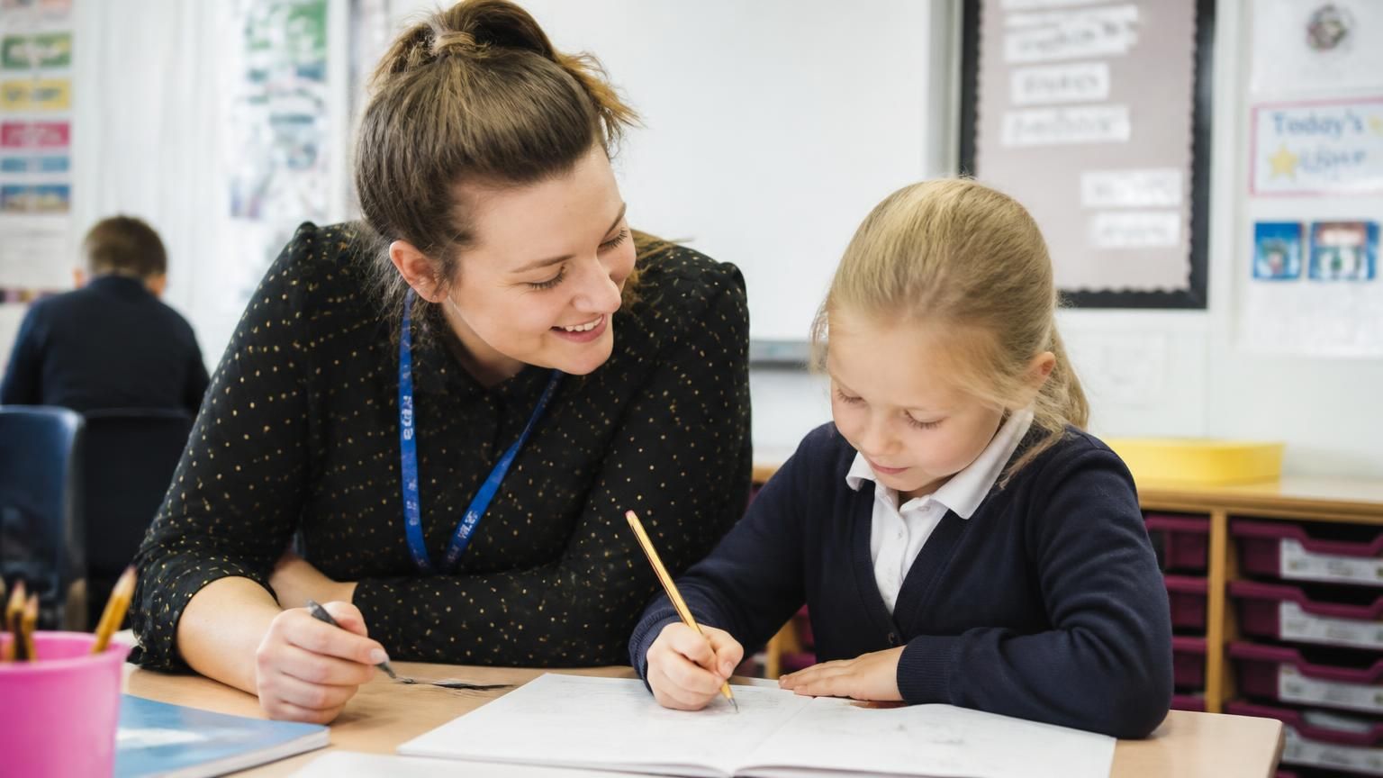A teaching assistant working one-to-one with a child in a Kent classroom - EHCPs in Kent: applying, timelines, and what happens if you disagree